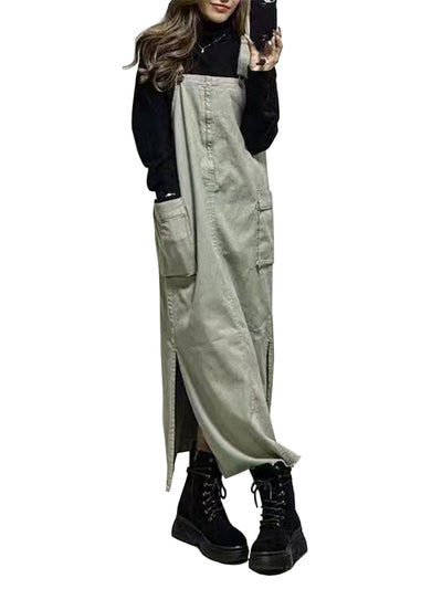 Person wearing a long light green overalls over a black outfit on a white background